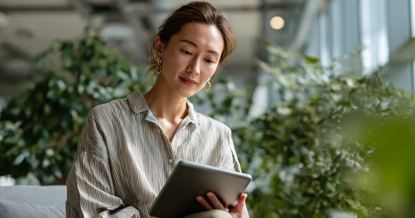 Professional woman reviewing tablet in modern office with plants