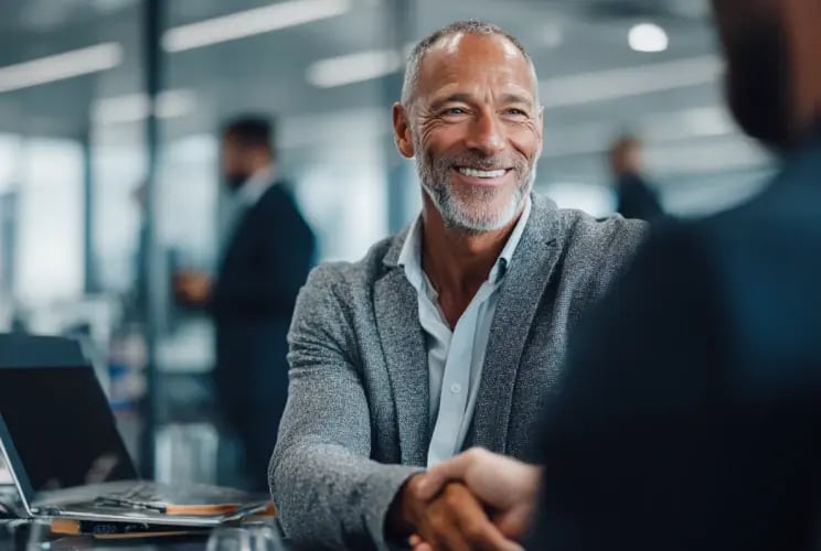 Mature business professional smiling during office meeting about economic substance compliance services