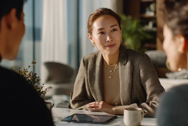 Professional woman in business attire meeting with clients in modern office setting